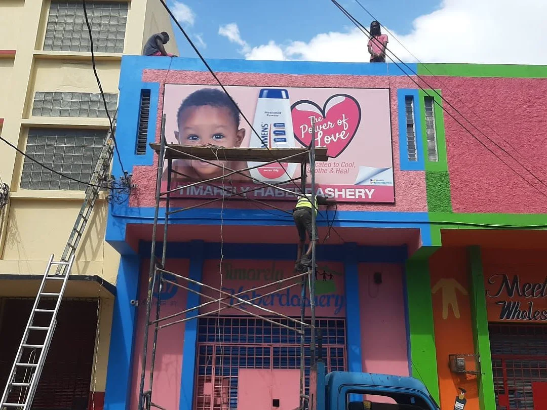 Colourful storefront signage being installed